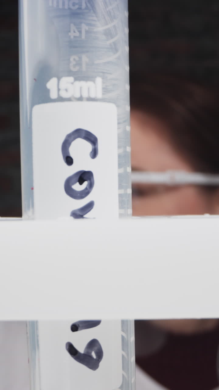 Scientist puts test tube with investigated blood sample and word Covid on rack in lab slow motion. Probe lens footage of virus research macro view