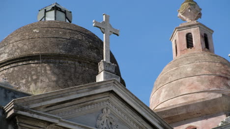 Mausoleum domes with crosses at daytime in La Recoleta Cementery tight shot panning right to left