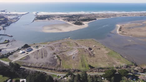 Beautiful-4K-aerial-overview-of-Bandon-Oregon-beach-and-harbor,-calm-sunny-day