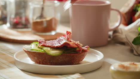 preparing a delicious open-faced cucumber and ham sandwich for breakfast