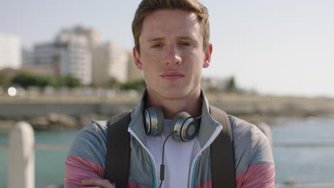 portrait of young red head teenager looking serious arms crossed on sunny beachfront