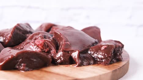 raw liver pieces on a wooden cutting board