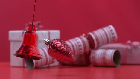 animation of christmas baubles over christmas cracker and git on red background