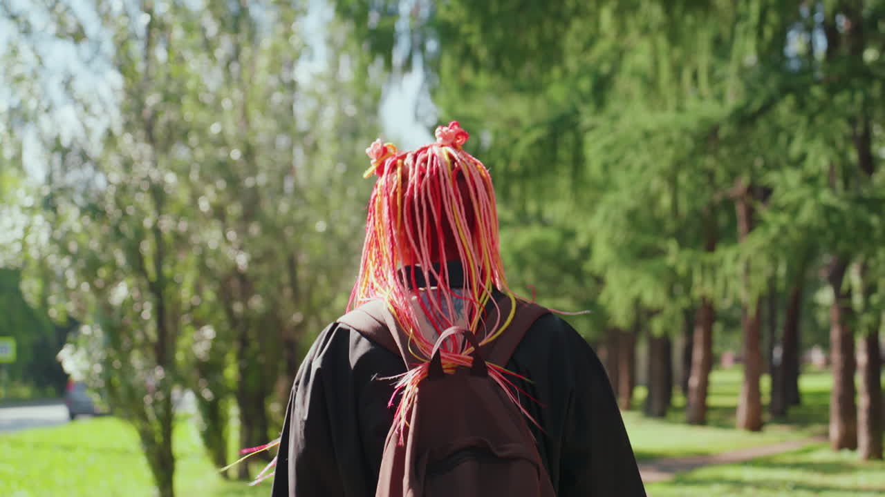 공원 산책로를 거닐고 있는 여성, 그늘진 도시 공원 산책로를 여유롭게 탐험하는 차분한 여성의 모습, 다채로운 머리카락을 가진 평화로운 여성이 조용한 도시 공원 환경을 천천히 탐험하고 있어요.