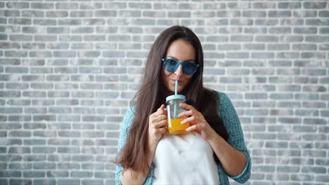 una mujer bebiendo jugo de naranja.