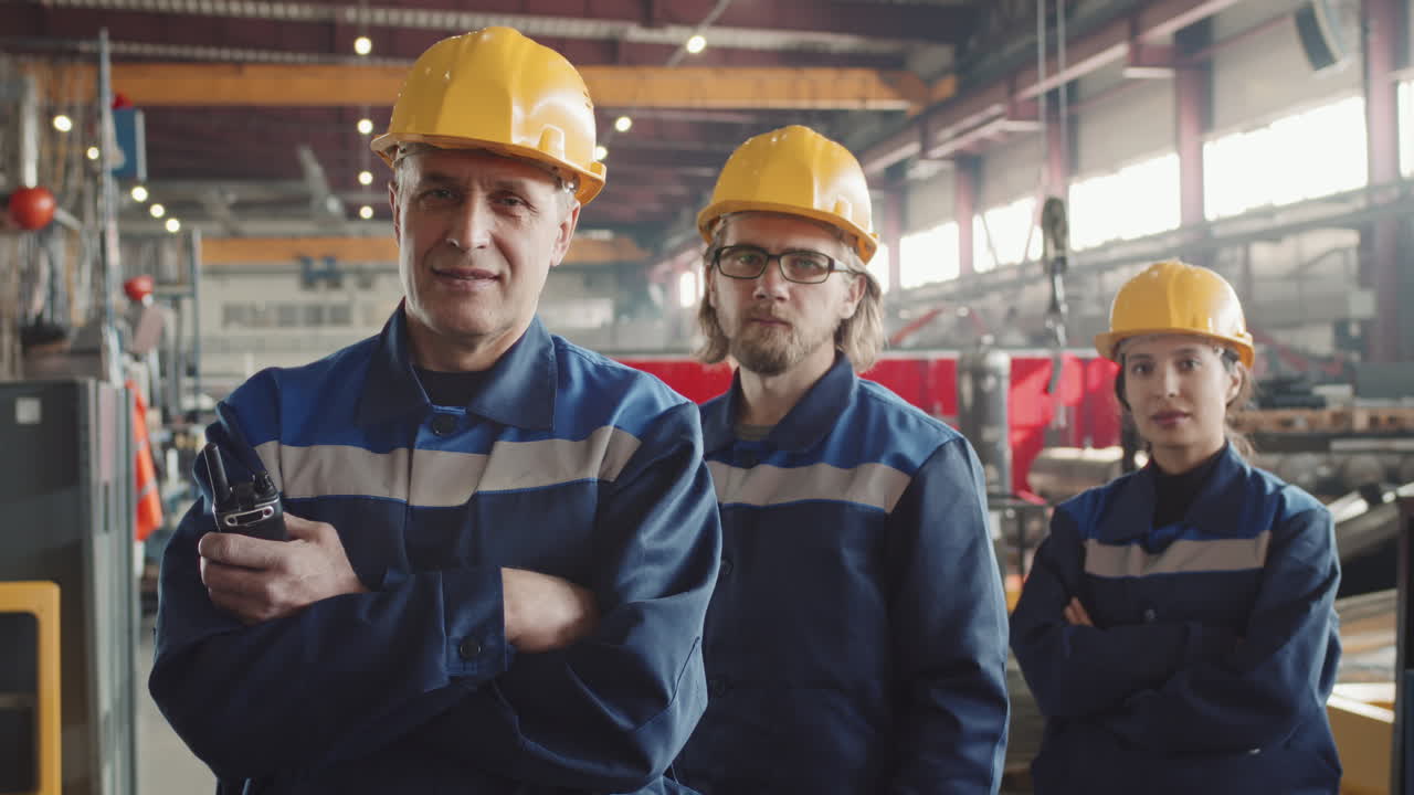 Smiling Plant Supervisor With Workers Posing For Camera