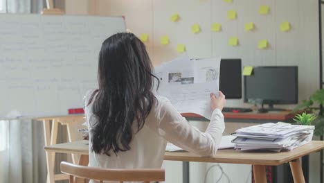 vista trasera de la presión mujer asiática arrojar el papel mientras trabaja duro con documentos en la oficina