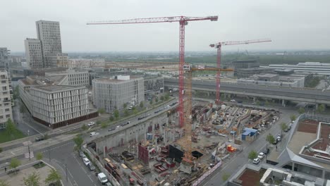 ariel view of a construction site in wien, capital of austria. landscape view of huge crawler cranes standing tall on the worksite surrounded by roads, commercial and residential buildings in vienna.