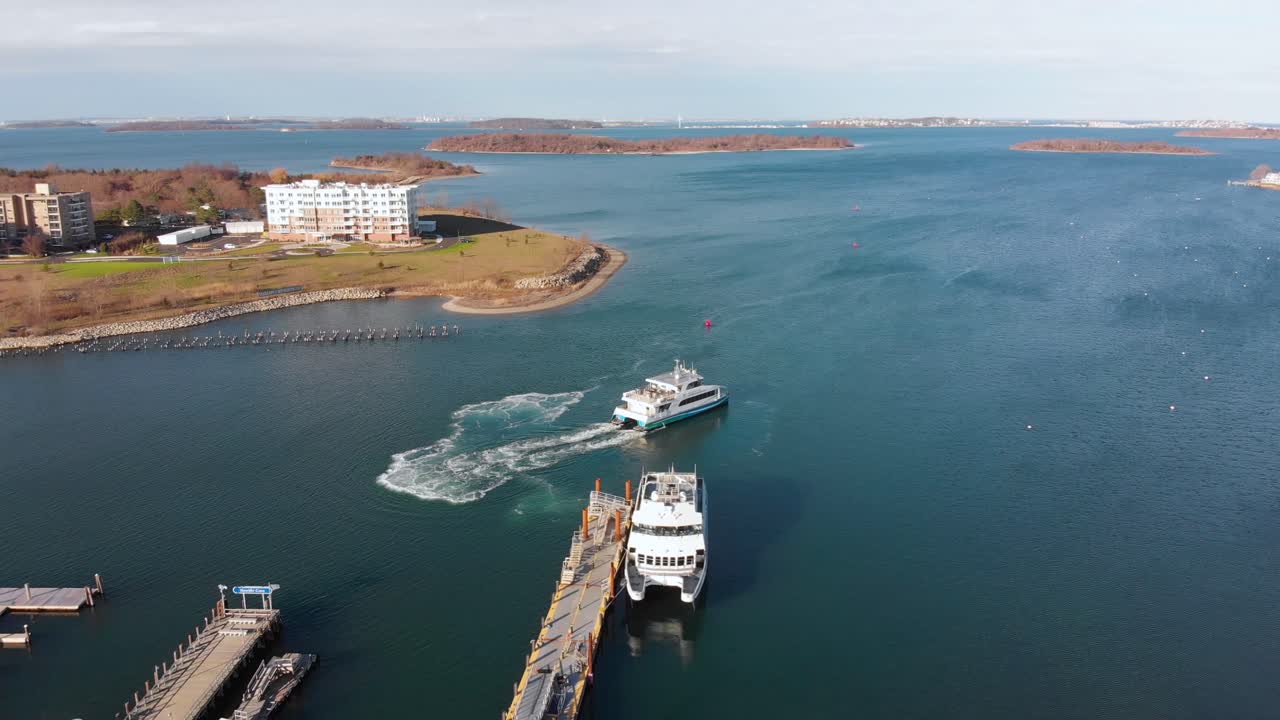 교외 해안가 커뮤니티의 부두에서 멀어지는 페리의 주간 무인 항공기 보기