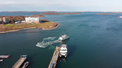 daytime drone view of a ferry pulling away from dock in a suburban waterfront community