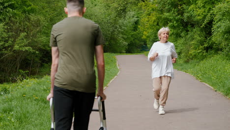 young man supporting elderly woman on a walk in a park