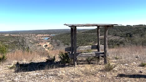 a bench and trough overlooks the hill country of texas, icon of the american west