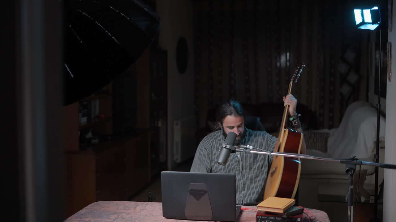 hombre tocando la guitarra acústica en el estudio casero