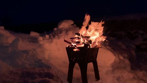 la leña apilada en la parrilla arde bien y brillantemente por la noche.