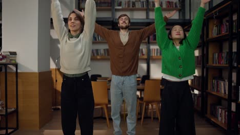 happy friends stretching in a library