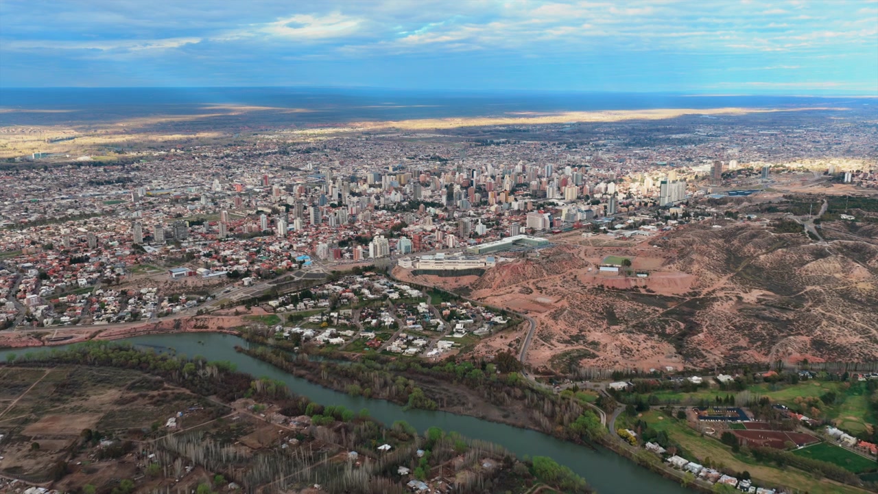 Vista aérea da cidade de Neuquén, mostrando a área urbana, o rio e a paisagem ao redor na Argentina