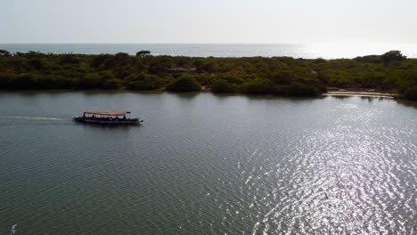 cinematic rotating panoramic shot of local tourist boat sailing on river gambia in kartong