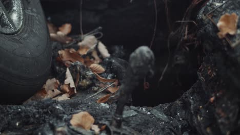 Racking-focus-on-stick-shift-of-burned-out-car-covered-in-leaves