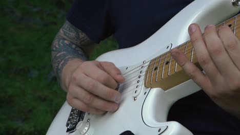 hombre tocando la guitarra frente a una hermosa cascada en islandia-4