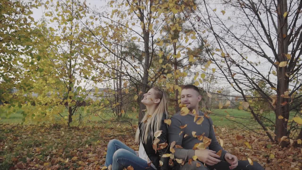 пара играет в осенних листьях