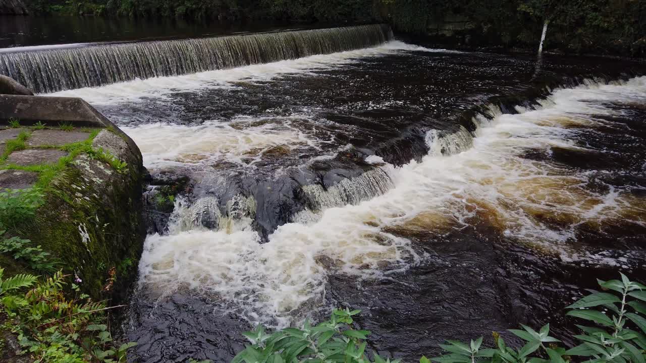 Closeup of the river Navy flowing over four weirs just after passing the English town of Tavistock in the county of Devon
