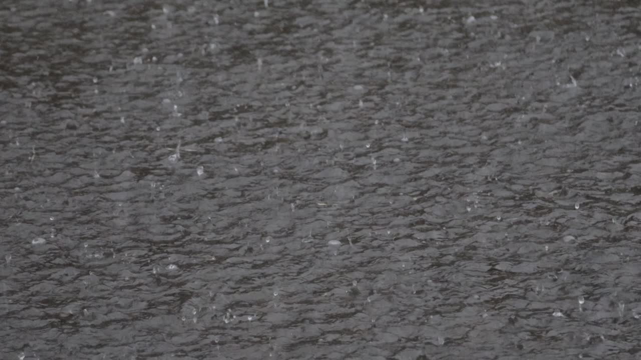 heavy rain, raindrops on the surface of the river with an irregular pattern