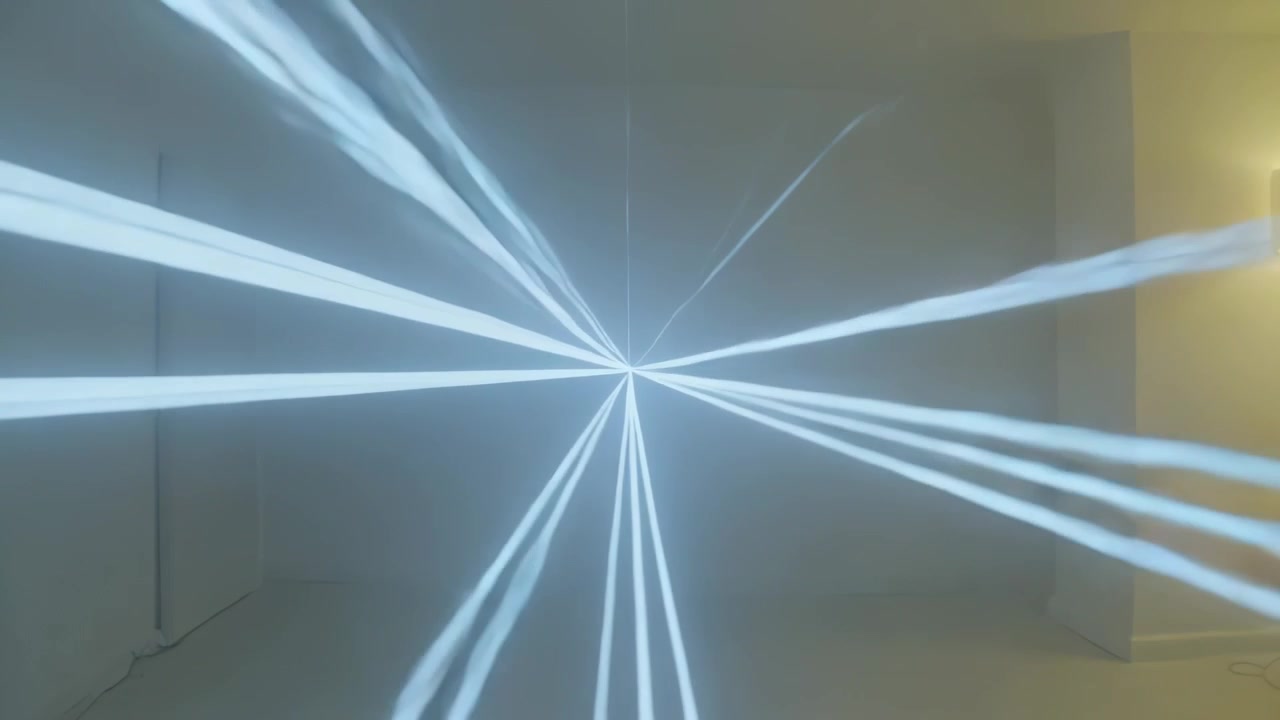 Turning projector sending bright point of light and narrow white beams sweeping room by wall sconce