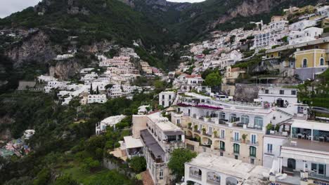 vista de drones volando sobre villas con terraza en la ladera, calles estrechas y antiguas ruinas romanas de la ciudad de positano, italia