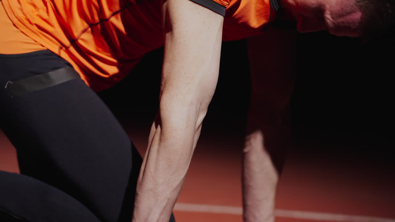 Man in orange shirt preparing for a workout