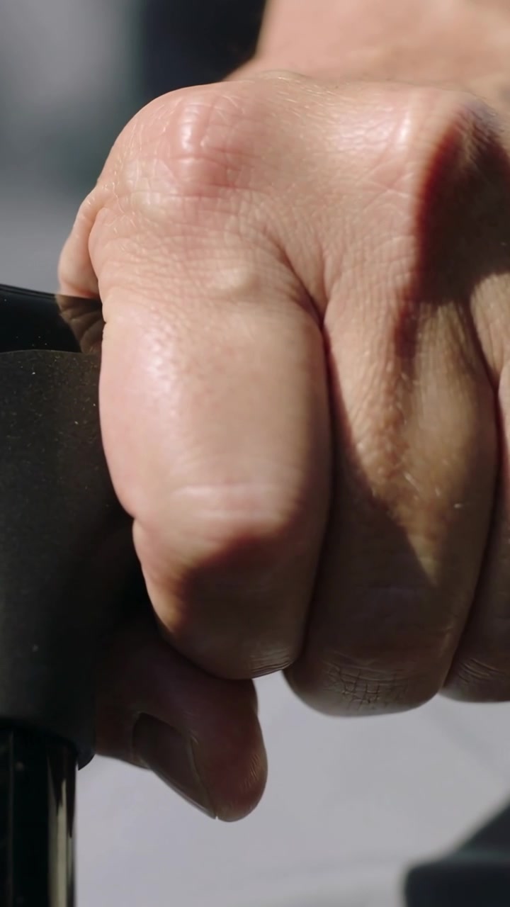 Right hand settling onto black handle, tightening fingers and steadying grip for cycling control