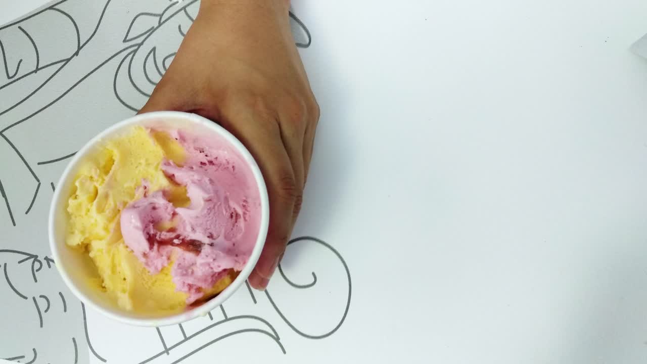 Dettaglio di una donna che mangia un delizioso gelato alla vaniglia e fragola