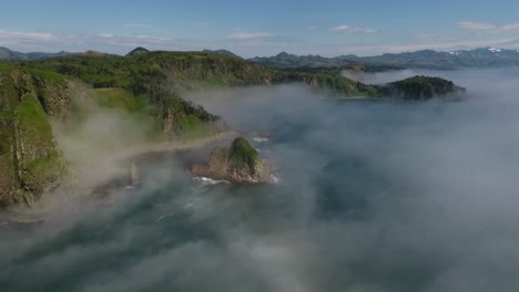 Drohnenclip-Einer-Gruppe-Abgelegener-Felsiger-Inseln-Mit-Nebliger-Lagune-Dazwischen