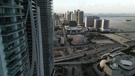 el horizonte del rascacielos del centro de miami con coches de carretera conduciendo y grúa de construcción durante el atardecer imágenes aéreas