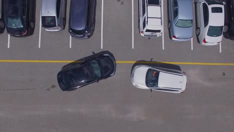 Two-cars-trying-to-get-into-the-same-parking-spot,-4k-drone-direct-overhead