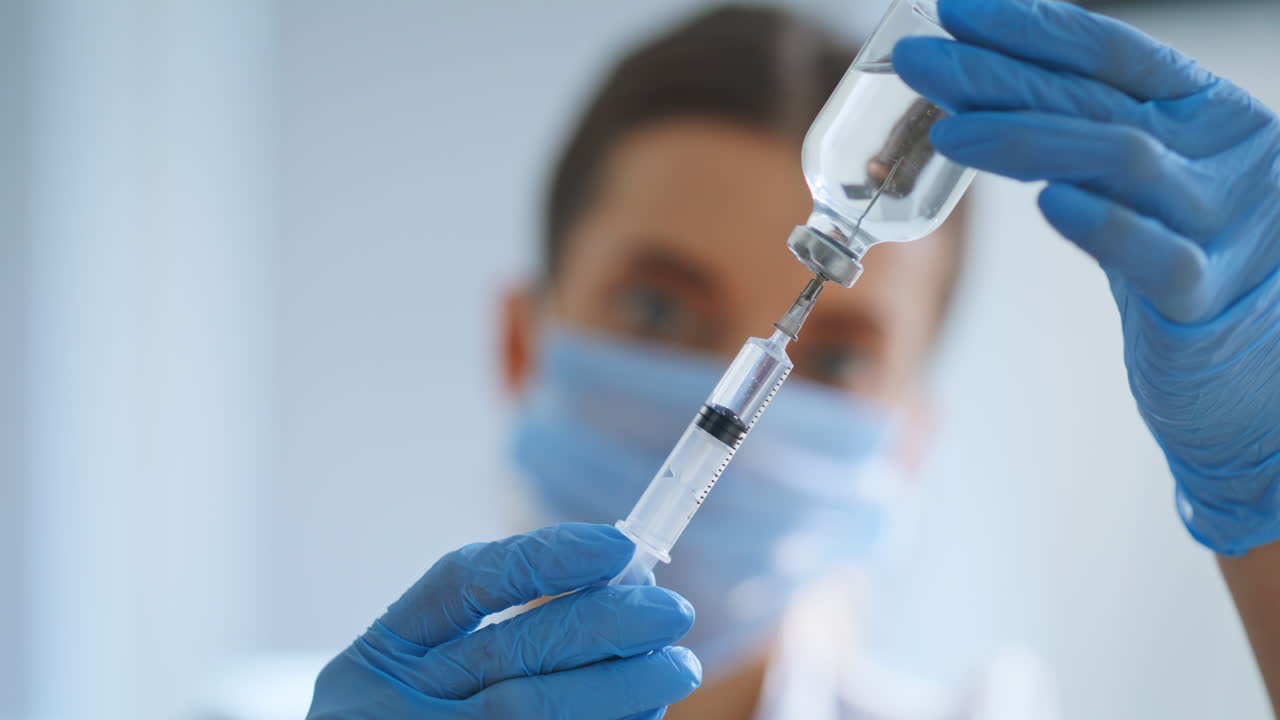 Medical syringe fulled drug in doctor hands closeup. Nurse holding injection