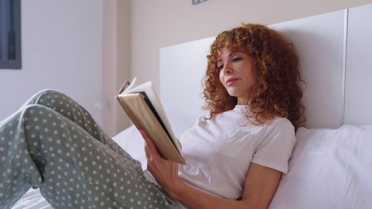 Femme lisant un livre dans le lit