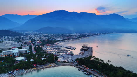 Flight over the popular resort with developed touristic infrastructure. Aerial view on Kemer, Turkey at dusk time