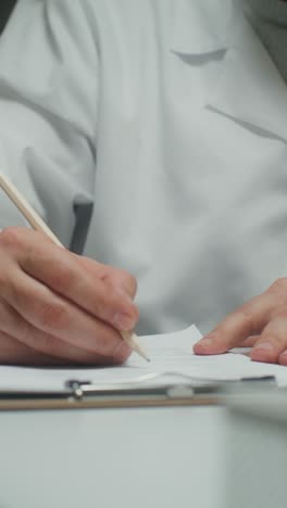 person writing on paper with pencil