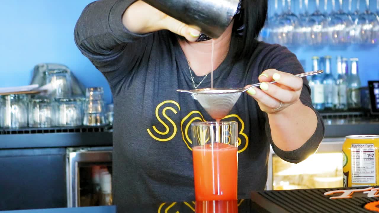 barman sirviendo una bebida en un vaso