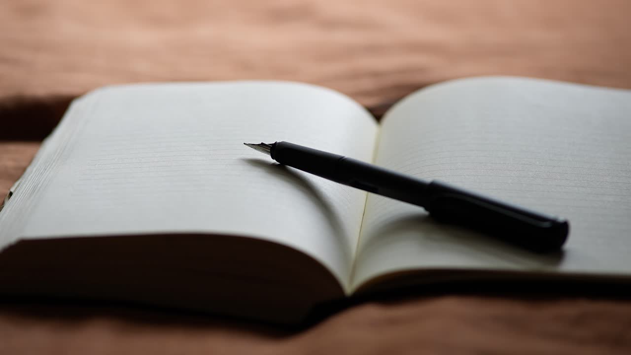 Fountain Pen lying uncapped on Blank Journal