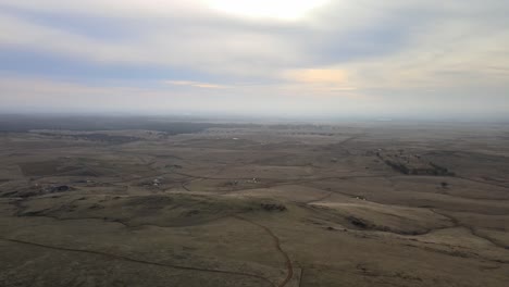 Flying-from-very-high-down-above-a-grassy-area-of-the-Central-Valley-foothills-of-the-Sierra-Nevada-mountains-in-California