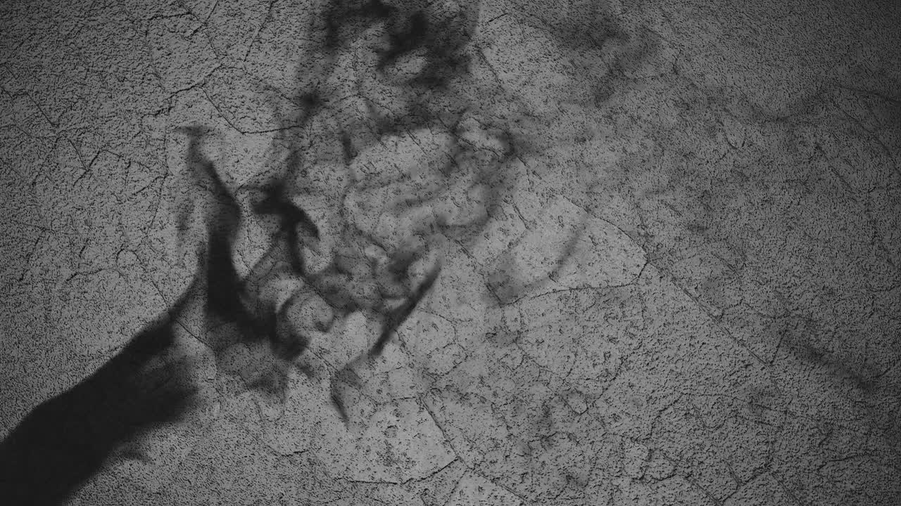 sombra de una mano contra un fondo negro con textura