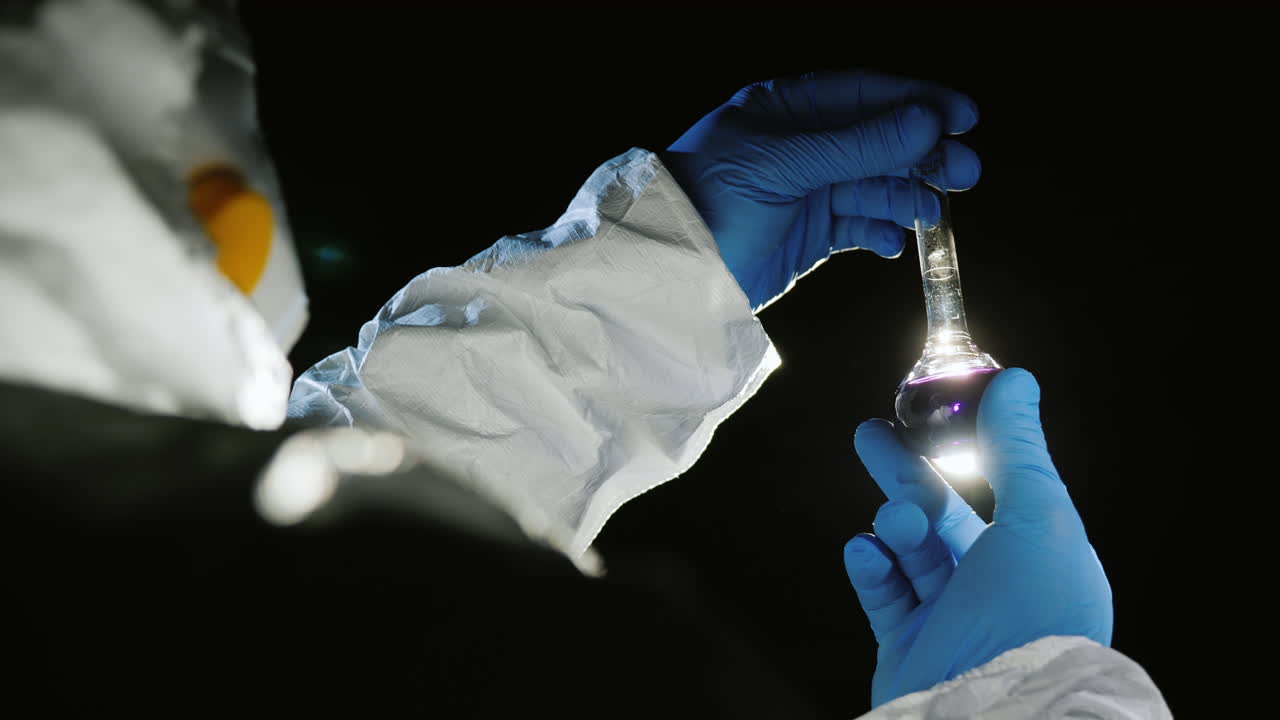 científico sostiene un tubo con un líquido rosa