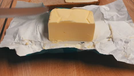 las manos cortan la mantequilla rápidamente con un cuchillo