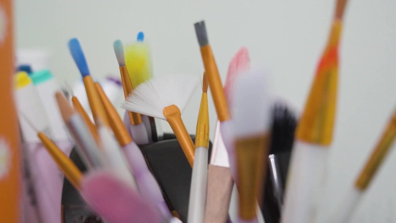 Level camera view of paint brushes in various states of wear and use.