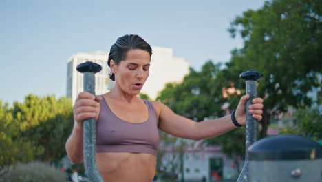 satisfecha señora máquina elíptica entrenamiento parque de primer plano. mujer terminando ejercicios