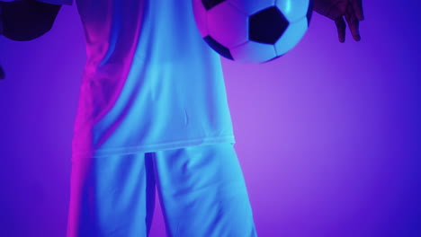 Close---up-of-a-soccer-ball-at-the-feet-of-a-football-player-in-the-studio-in-slow-motion-.-Professional-football-player-with-a-ball-in-the-studio