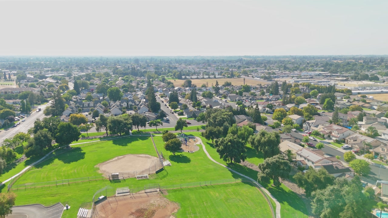 Elevated drone footage of the Oakdale area highlights residential homes, streets, and suburban character, useful for Central Valley housing and California lifestyle.