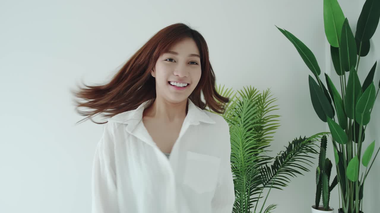 흰 셔츠를 입은 아시아 여성의 추적은 흰색 방에서 좋은 느낌을 줍니다.