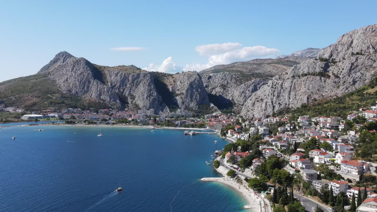 Massive steel grey mountains above Omis, a coastal town in Croatia, an aerial view
